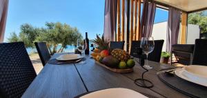 迪斯诺VORTEX mobile homes的一张木桌,上面放着一碗水果和酒杯