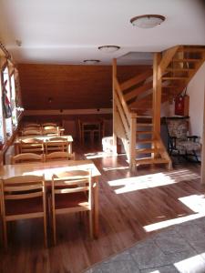 马科夫Penzion Adam - Makov的客房设有木桌、椅子和楼梯。