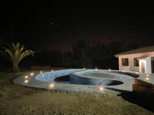 塔里哈Hotel Poneloya的夜间游泳池周围灯光环绕