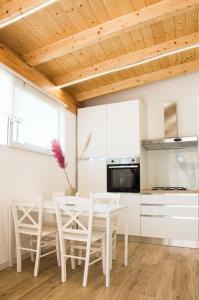 泰拉奇纳VILLA AMBROSIA 172 A的厨房配有白色橱柜和桌椅