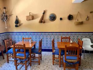 卡斯特里尔Alojamiento Rural Mar de Olivos的用餐室设有木桌、椅子和墙壁
