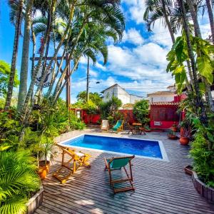 布希奥斯波萨达维勒盖尼昂宾馆的一个带游泳池和棕榈树的后院