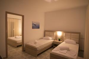 普萨克迪亚Porto Psakoudia的酒店客房,设有两张床和镜子