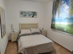 伊斯兰蒂拉Islantilla primera linea de playa, piscina, parking的卧室配有一张床,墙上挂有绘画作品