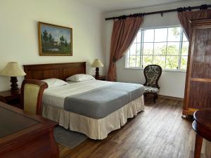 维多利亚Beau Séjour Hotel的一间卧室设有一张大床和一个窗户。