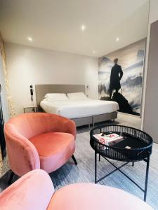 艾克斯莱班德拉库罗讷酒店的一间卧室配有一张床、一把椅子和一张桌子