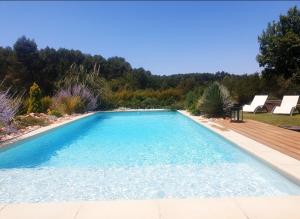 欧巴涅Les Prairies de Fenestrelle Spa & Piscine au calme的一个带木甲板的庭院内的游泳池