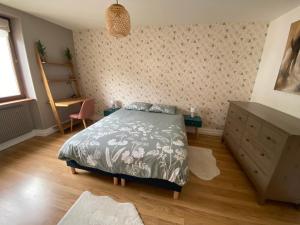 热拉梅Les brimbelles的一间卧室配有一张床和一个梳妆台