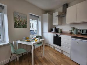 克罗默Charming 1-Bed Apartment in Cromer Town Centre的厨房配有桌椅、桌子和柜台。