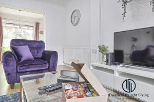 巴塞尔顿Purple Velvet - 2 Bed Home Spacious - Basildon Essex Upto 5 Guests, Free Wifi , Free Parking的客厅配有紫色椅子和电视