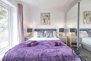 巴塞尔顿Purple Velvet - 2 Bed Home Spacious - Basildon Essex Upto 5 Guests, Free Wifi , Free Parking的一间卧室配有一张带枕头的紫色床。