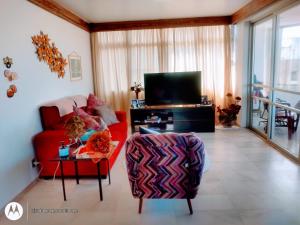 马塞约Quarto em Apto Compartilhado BEIRA MAR的客厅配有红色沙发和电视