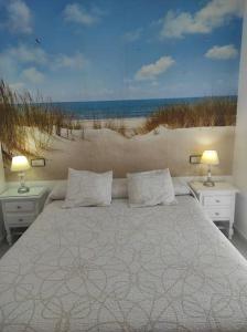 伊斯兰蒂拉islantilla adosado piscina parking 1 minuto al mar的一间卧室配有一张床,享有海滩美景