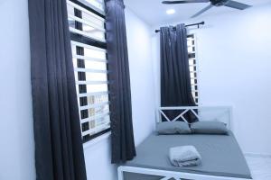 哥打巴鲁Green Dream Homestay 3 Kota Bharu 3 Aircond Room With Wifi & Netflix的配有黑色窗帘的房间的靠窗座位