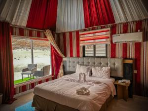 瓦迪拉姆Sun Luxury Rum Camp的一间卧室配有一张带红色窗帘的床和一扇窗户