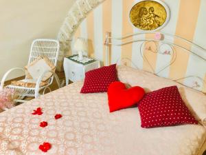 莫尔费塔SOTTO L’ARCO DI NUNZIELLA的一张带两个红色枕头的床,上面有心