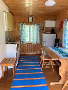 普马拉Lappalaisen lomamökit Pihamökki的一间小厨房,配有桌子和蓝色地毯