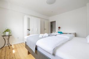 霍尔茨维克德Modernes Zuhause - Küche - Top Anbindung - High WLAN的白色卧室配有一张带白色床单的大床