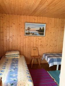 普马拉Lappalaisen lomamökit Pihamökki的小屋内带两张床和椅子的房间