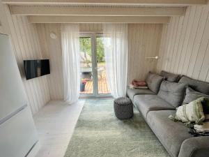 库雷萨雷Fully equipped new tiny-house的客厅配有灰色的沙发和电视