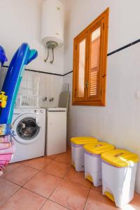 坎波斯Casa rural, finca rústica con piscina Cas Padrins de Campos, Mallorca的洗衣房配有洗衣机和黄色凳子