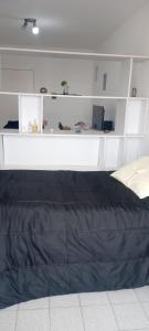 布宜诺斯艾利斯La Recova de La Boca的卧室配有床和白色架子