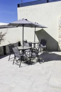 恩塞纳达港Habitación 23 - Green Casitas的庭院内桌椅和遮阳伞