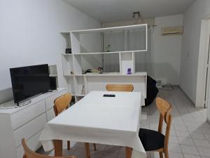 布宜诺斯艾利斯La Recova de La Boca的一间配备有白色桌椅的用餐室