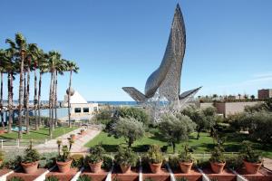 巴塞罗那巴塞罗那艺术酒店的享有公园美景,公园内拥有雕像和棕榈树