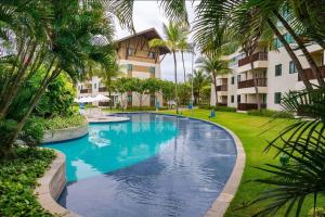 嘎林海斯港Flat térreo 2 quartos no Marulhos Resort - Beira mar Muro Alto的棕榈树度假村内的游泳池