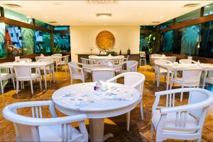 嘎林海斯港Flat térreo 2 quartos no Marulhos Resort - Beira mar Muro Alto的用餐室配有白色的桌子和白色的椅子