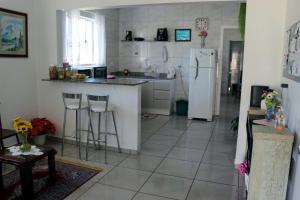 弗洛里亚诺波利斯Pousada Decarli Executiva Aeroporto Florianópolis的厨房配有白色冰箱,铺有瓷砖地板。