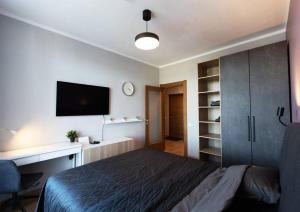 里加Stylish apartment with parking & spacious balcony的一间卧室配有一张床、一张书桌和一台电视。