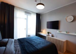 里加Stylish apartment with parking & spacious balcony的一间卧室配有一张床和一台平面电视