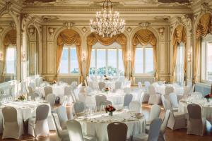 蒙特勒Grand Hotel Suisse Majestic, Autograph Collection的一间设有白色桌椅和吊灯的客房