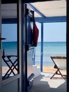 ProvatasCave Beach House Milos的享有海滩景致的客房,配有红色的袋子