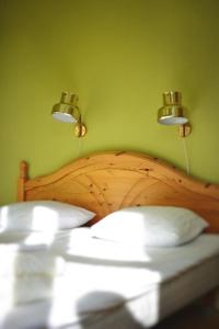 尤城Piece of Hjo Vandrarhem的一间卧室配有木床,上面有两盏灯