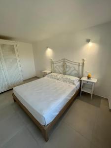 伊斯基亚Marintò Apartaments的卧室配有一张白色的大床和两张桌子