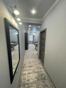阿拉木图ЖК Lotus terrace的走廊上设有镜子,走廊上设有房间