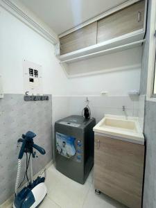 内瓦CB Somos AT HOME Apto cómodo e impecable con Aire Acondicionado的一个带水槽和洗衣机的小厨房