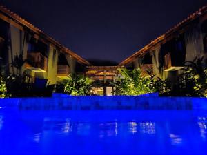 鲍巴Pousada Vila Ipuan的夜间带游泳池的度假村