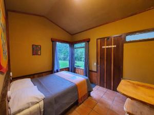 蒙泰韦尔德哥斯达黎加Finca Terra Viva的一间卧室设有一张床和一个大窗户