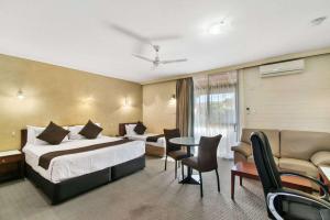 怀阿拉Comfort Inn Whyalla的酒店客房带一张床、一张桌子和椅子