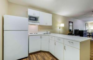 拉伯克美国长住酒店 - 拉伯克 - 西南的厨房配有白色橱柜和白色冰箱。
