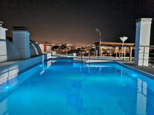 马贝拉Penthouse with private pool, hot tub jacuzzi with sea views and chill-out zone, close to the sea的一座游泳池,在晚上在一座建筑的顶部