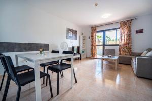 科拉雷侯Oasis Fuerteventura的客厅配有桌椅和沙发