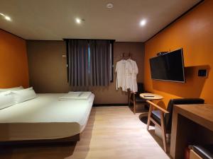 釜山Foxy Hotel的一间酒店客房,配有一张床和一台电视