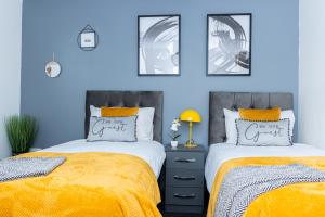 伍尔弗汉普顿TD Carsh Wolverhampton - Luxurious 2 Bed House - Sleeps 6 - Perfect for Long Stay Workers - Leisure - Families的卧室设有两张床铺和蓝色的墙壁