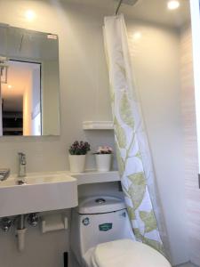 Tile HillBreeze Homstay的浴室设有卫生间、水槽和淋浴帘