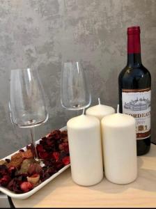 华沙AirPort Apartment的一瓶葡萄酒和两杯酒以及一盘食物